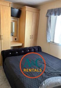 a bedroom with a bed with an ac repairs sign on it at A&C rentals in Skegness +6 photos
