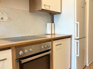 a kitchen with a stove top oven next to a refrigerator at Malfatti Room Oasis Space in Vienna
