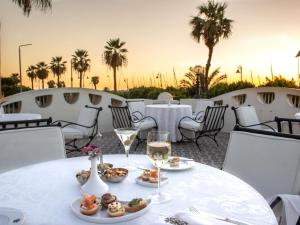 a table with plates of food and glasses of wine at Pavillon Winter Luxor in Luxor