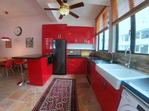 a kitchen with red cabinets and a black refrigerator at The Red House in Hong Kong