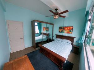 a bedroom with a bed and a ceiling fan at The Red House in Hong Kong