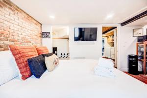 a bedroom with a white bed and a brick wall at Eagle's Landing - Logan Airport in Boston