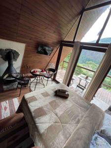 a bedroom with a large bed and a table and chairs at Chalé Águia in Petrópolis