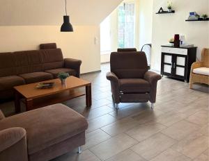 a living room with a couch and chairs and a table at Ferienwohnung Jasi, OG 95174 in Rhauderfehn