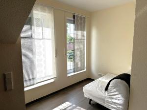 a bedroom with two windows with blinds on them at Ferienwohnung Jasi, OG 95174 in Rhauderfehn