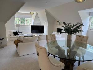 a living room with a glass table and white furniture at LM Manor B&B in Little Massingham