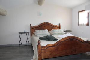 a bedroom with a large wooden bed with two pillows at Maison de charme à Mérindol + Jardin in Mérindol +15 photos