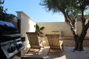 two chairs sitting on a patio with a tree at Maison de charme à Mérindol + Jardin in Mérindol