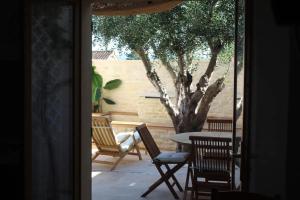 a patio with chairs and a table and a tree at Maison de charme à Mérindol + Jardin in Mérindol