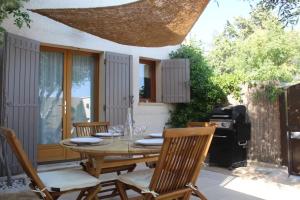 a wooden table and chairs on a patio at Maison de charme à Mérindol + Jardin in Mérindol
