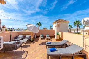 a patio with chairs and an umbrella on a balcony at ALBA by the Sea in Punta Prima