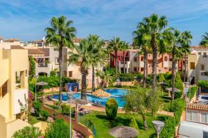 an aerial view of a resort with a swimming pool and palm trees at ALBA by the Sea in Punta Prima