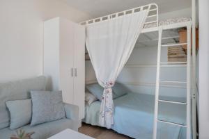 a bedroom with a bunk bed and a couch at Estudio Limón y Sal in Chiclana de la Frontera