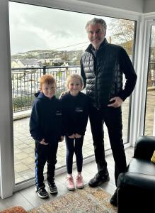 a man and two boys standing in front of a window at BayView Luxury 4 Bedroom Penthouse in Downings
