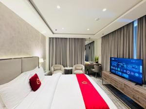 ein Hotelzimmer mit einem großen Bett und einem Flachbildfernseher in der Unterkunft TAJ Signature Hotel - Jinnah Super F7 Islamabad in Islamabad