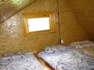 two beds in a small room with a window at Guest house Oaze in Miglāni