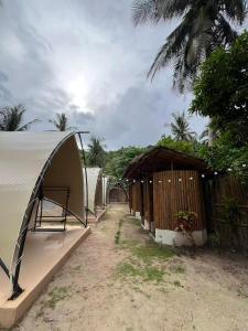 a row of tents next to a row of houses at Milky Way Glamping in Busuanga