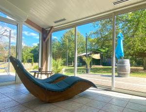 a large wooden hammock sitting on a screened in porch at Le Grand Bain in Marciac