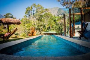 a swimming pool at a resort with mountains in the background at Chalé Águia in Petrópolis