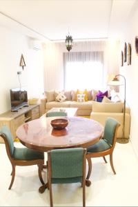 a living room with a table and chairs and a couch at Azra Mila Appart luxe famille uniquement in Saidia 