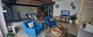a living room with blue chairs and a table at Gîte La Grange au cœur des châteaux in Saint-Georges-sur-Cher