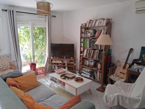 a living room with a couch and a tv at Chez Loti in Louviers