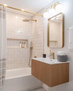 a bathroom with a tub and a sink and a mirror at Huge Modern Chalet on Trestle Trail New Paltz & Rosendale in Rosendale +33 photos