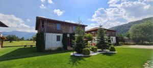 a house with a yard with trees in front of it at Villa Nikol Apt #2 in Raduil