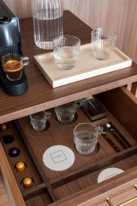 a wooden cabinet with glass bowls on a shelf at NAMAN HOTELLERIE - Condotti in Rome