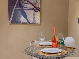 Una mesa de cristal con dos copas y una botella de vino. en Blu Rooms Guesthouse, en Civitanova Marche
