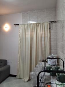 a living room with a shower curtain and a couch at Adriel House in Dodoma