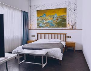 a bedroom with a bed and a painting on the wall at Suzhou Unique Space Design Art Hotel in Suzhou