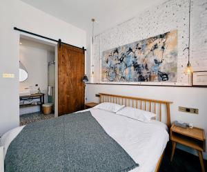 a bedroom with a bed and a painting on the wall at Suzhou Unique Space Design Art Hotel in Suzhou