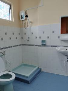 a bathroom with a shower and a toilet and a sink at Iris 2 Bedroom Pool View Balcony in Kampong Tanah Merah