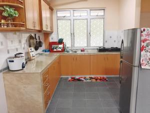 a kitchen with a refrigerator and a tile floor at Iris 2 Bedroom Pool View Balcony in Kampong Tanah Merah