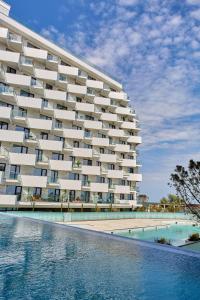 ママイア・ノルドにあるApartament Atlantis by Infinity ALZの大きな建物で、目の前にスイミングプールがあります。