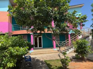 a colorful house with a tree in front of it at The Accra Backpackers Hostel in Accra +8 photos