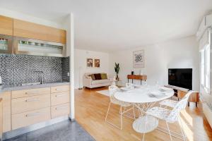 a kitchen and living room with a white table and chairs at Apt Cosy - AC-1CH-4P - Suresnes-Parc du Chateau in Suresnes