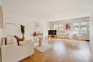 a living room with a couch and a tv at Apt Cosy - AC-1CH-4P - Suresnes-Parc du Chateau in Suresnes