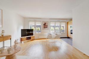 a living room with a television and a table at Apt Cosy - AC-1CH-4P - Suresnes-Parc du Chateau in Suresnes +4 photos
