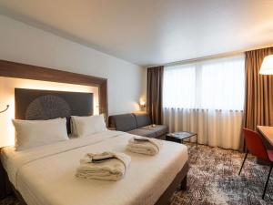 una camera d'albergo con un letto con asciugamani sopra di Novotel Paris Gare De Lyon a Parigi Altre 145 foto