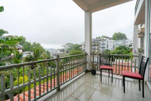 a balcony with two chairs and a view of a city at The Cloud Hanthana, Kandy in Kandy +60 photos