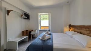 a bedroom with a bed and a desk and a window at LA PIAZZETTA - Homy 5 Terre in Volastra