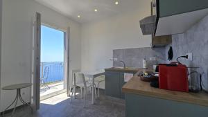 a kitchen with a counter and a table and a window at LA PIAZZETTA - Homy 5 Terre in Volastra