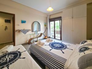 two twin beds in a room with a mirror at Emily's Paradise by SDR in Paralia Katerinis