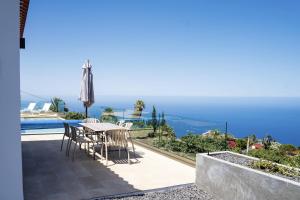 a table and chairs on a balcony with a view of the ocean at Finca Tomasa in Tijarafe