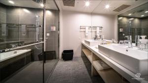 a bathroom with two sinks and a shower at Daiwa Roynet Hotel Kanazawa Eki Nishiguchi in Kanazawa