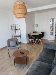 a living room with a couch and chairs and a table at Altitude Intérieure in Le Perrey