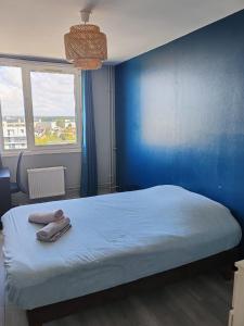 a blue bedroom with a bed and a blue wall at Altitude Intérieure in Le Perrey