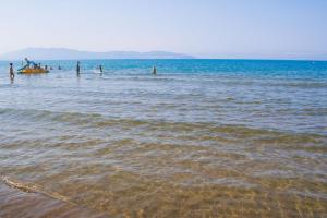 un grupo de personas en el agua en la playa en Residence with swimming pool in Albinia just 150 mt from the beach, en Albinia